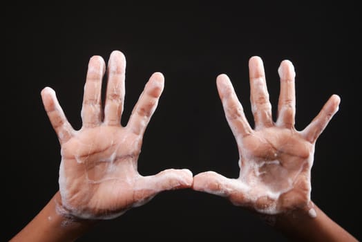 child boxy washing hands with soap isolated on black .