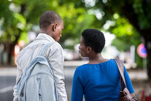 Young people standing in street giving back to the camera.