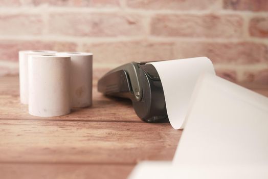 POS machine and long roll paper on table .