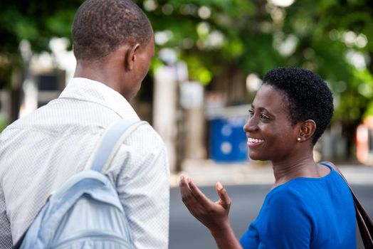 young girl standing in blue camisole talking to her friend smiling.