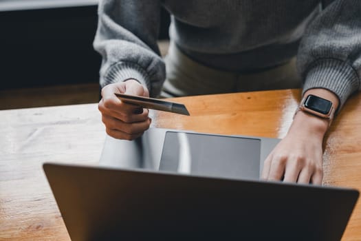 Close up young asian woman holding credit card and using tablet computer. Businesswoman working at home. Online shopping, e-commerce, internet banking, spending money, working from home concept.