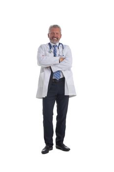 Full length portrait of happy mature doctor standing with crossed arms isolated on white background