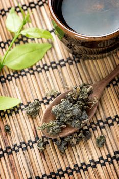 a cup of green tea on bamboo mat
