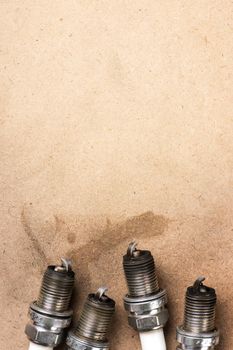 used spark plugs with soot on wooden background