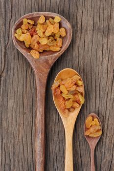 closeup heap of delicious raisins on wooden spoon