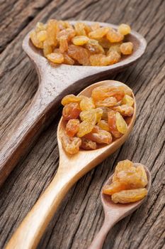 closeup heap of delicious raisins on wooden spoon