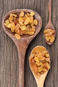 closeup heap of delicious raisins on wooden spoon