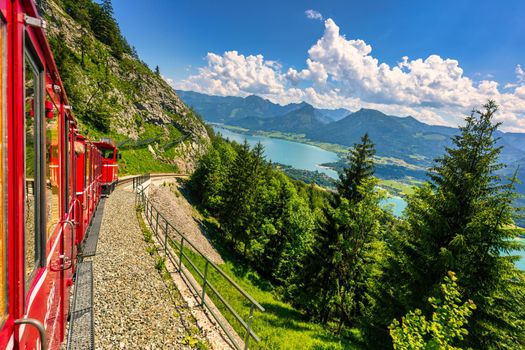 Schafbergbahn mountain train, Schafberg mountain, Salzkammergut region, Salzburg Land state, Austria. Journey to the top of Alps through lush fields and green forests.View of lake Wolfgangsee.