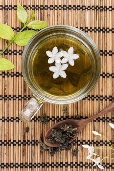 a cup of green tea on bamboo mat