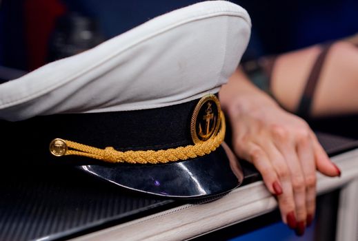 sailor's cap on the shelf of the woman's hand next to . High quality photo