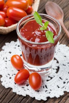 closeup a glass of ketchup and tomatoes