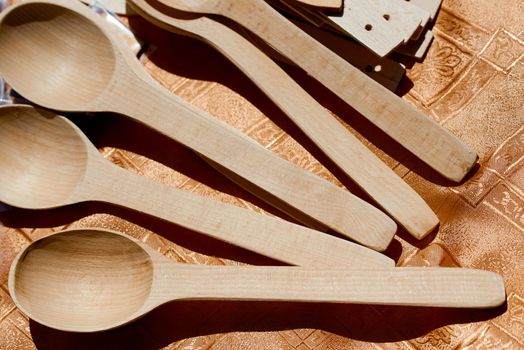 handmade wood spoons on wooden table under sun. High quality photo