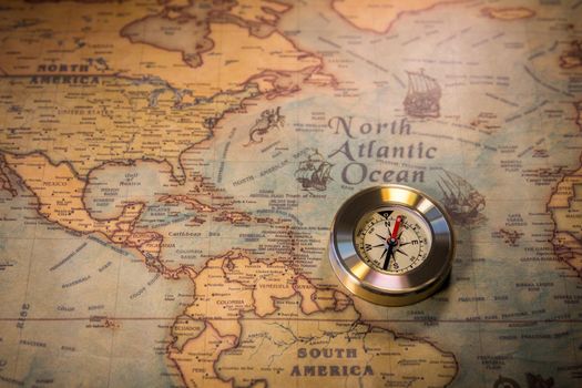 Old compass on vintage map. Adventure stories background. Retro style. The map used for background is in Public domain. Map source: Library of Congress. Country: Belgium Year: 1570. Author: Abraham Ortelius (1527-1598)