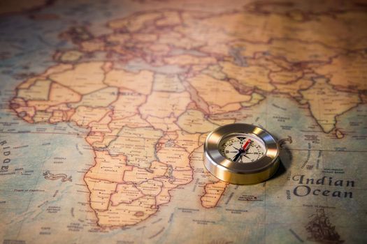 Old compass on vintage map. Adventure stories background. Retro style. The map used for background is in Public domain. Map source: Library of Congress. Country: Belgium Year: 1570. Author: Abraham Ortelius (1527-1598)