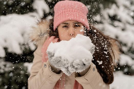 Merry Christmas and happy New Year. Close up of woman blowing snow, holding in hands