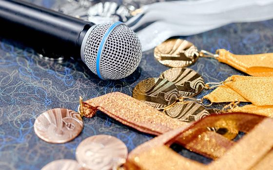 Awards, medals with ribbons on the table with a microphone . High quality photo