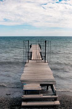 wooden pier in the sea on a cloudy day. Sea autumn landscape.