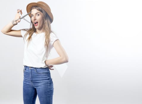 A woman wearing a hat looking through scissors hight quality