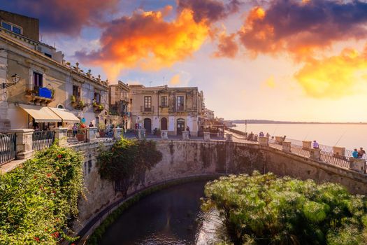 The Fountain of Arethusa and Siracusa (Syracuse) in a sunny summer day. Sicily, Italy. The Fountain of Arethusa in Ortygia, historical centre of Syracuse, Sicily, Italy.