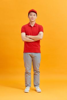 Deliveryman with arms crossed in studio. looking at camera. Full length portrait. isolated gray background