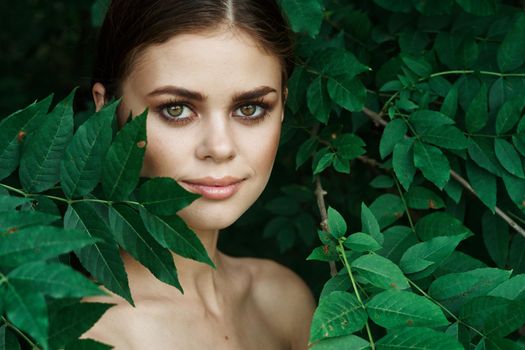 smiling woman green leaves clean skin nature summer close-up. High quality photo