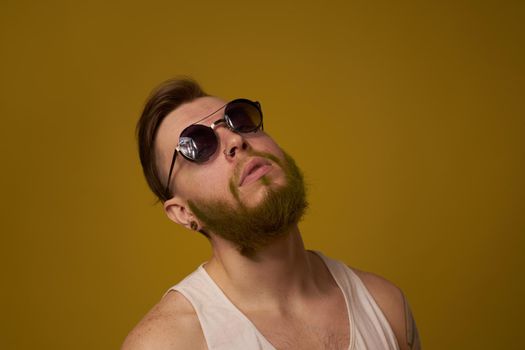 a bearded man with a serious expression in a white t-shirt with tattoos on his arms. High quality photo