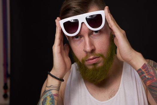 bearded macho man in white t-shirt sunglasses fashion tattoos. High quality photo