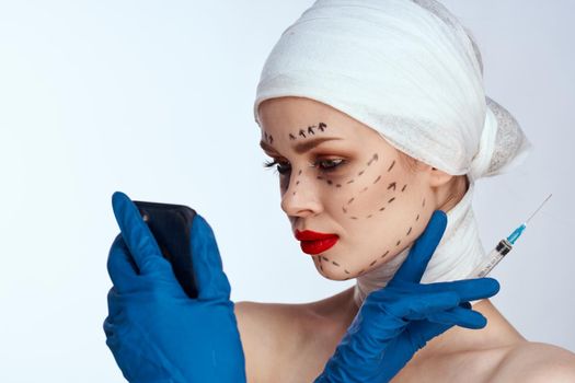 portrait of a woman in blue gloves syringe in hands contour on the face lifting isolated background. High quality photo