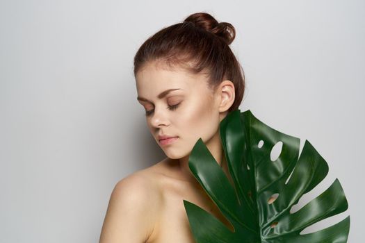 cheerful woman palm leaf bare shoulders studio model. High quality photo