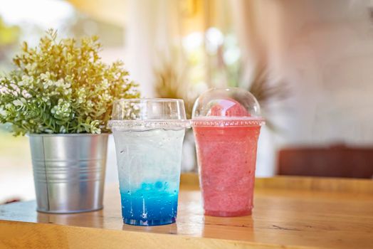 Blue soda in plastic cup put on table