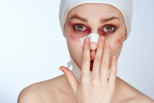 woman with bandaged face bruises syringe in hand painkillers light background. High quality photo