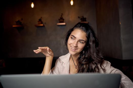 cheerful woman sitting in a cafe in front of a laptop communication internet lifestyle. High quality photo