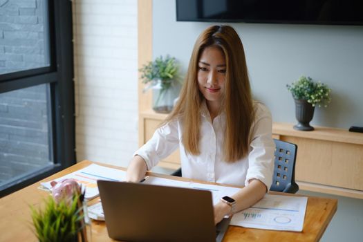 Photo of gorgeous secretary working at office. she sitting at the wooden desk