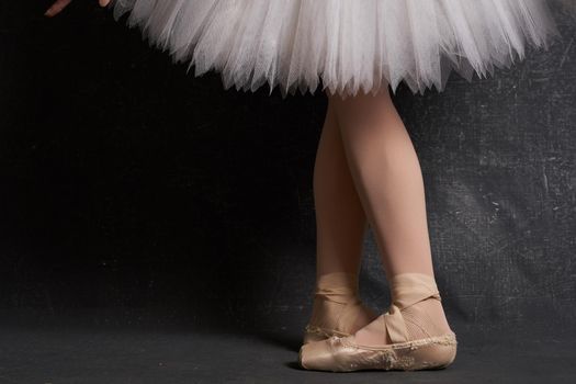 crossed legs ballerinas ballet shoes performance dark background. High quality photo