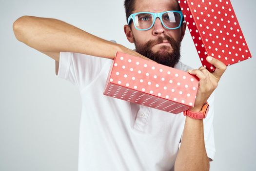 man with gift box wearing glasses holiday fun light background. High quality photo