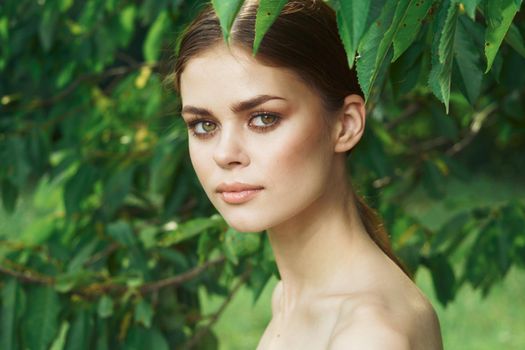 pretty woman attractive look bare shoulders green leaves cropped view. High quality photo