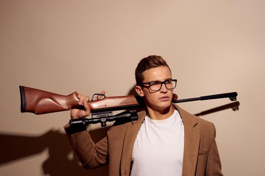 Man posing with glasses with a rifle in his hands isolated background. High quality photo