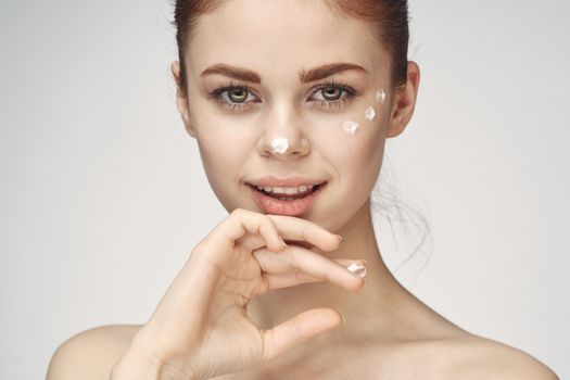 woman with face cream naked shoulders cosmetics face care. High quality photo