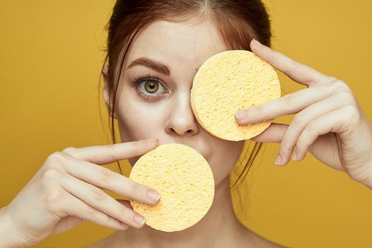 pretty woman with sponges in her hands bare shoulders clean skin hygiene. High quality photo