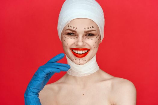 portrait of a woman in blue gloves syringe in hands contour on the face lifting red background. High quality photo