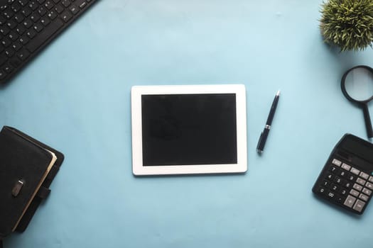 Flat composition of digital tablet and office stationary on black background .