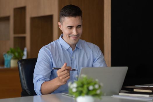 smiling businessman having virtual team meeting call, talking, remotely working at home watching online learning training webinar in remote office.