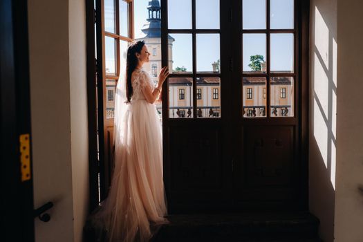 An elegant bride on the balcony of an ancient castle in the city of Nesvizh.