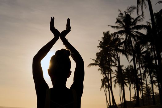 beautiful woman meditating outdoors. bali black beach