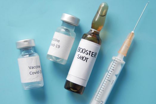 Close up of coronavirus vaccine and syringe on black background.