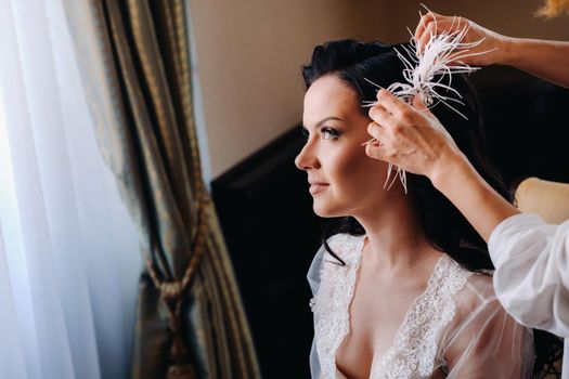 The bride is decorated with feathers in her hairstyle.Morning of the bride.