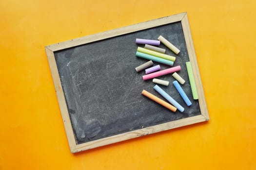 colorful chalk and chalkboard on black background .