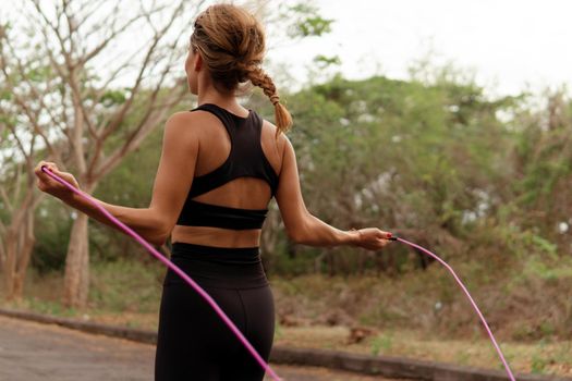 woman in black sportwear jumping rope. bali