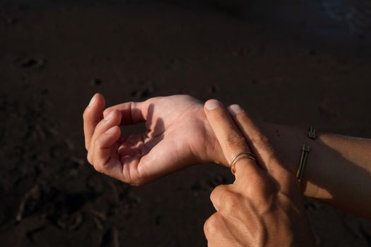 woman measures her pulse on the beach. bali