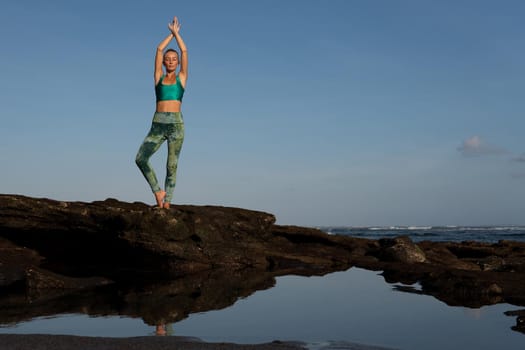 beautiful woman doing yoga on the beach. bali